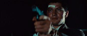 Movie still from “The Way of the Dragon” (1972), directed by Bruce Lee – A man in a suit and tie holding a gun; Close Up shot, Low angle