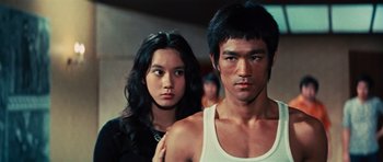 Movie still from “The Way of the Dragon” (1972), directed by Bruce Lee – A man and a woman standing next to each other; Close Up shot, Low angle