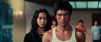 Movie still from “The Way of the Dragon” (1972), directed by Bruce Lee – A man and a woman standing next to each other; Close Up shot, Low angle