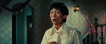 Movie still from “The Way of the Dragon” (1972), directed by Bruce Lee – An asian man wearing a white shirt and a tie; Close Up shot, Low angle