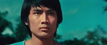 Movie still from “The Way of the Dragon” (1972), directed by Bruce Lee – A person wearing a blue shirt; Close Up shot, Low angle