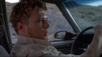 Movie still from “The Way of the Gun” (2000), directed by Christopher McQuarrie – A man sitting in the driver's seat of a car; Close Up shot, Low angle