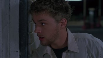 Movie still from “The Way of the Gun” (2000), directed by Christopher McQuarrie – A person wearing a white shirt; Close Up shot, Low angle