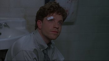 Movie still from “The Way of the Gun” (2000), directed by Christopher McQuarrie – A man with bandages on his head and a bandage on his face; Close Up shot, Over the shoulder angle