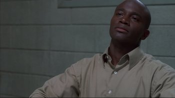 Movie still from “The Way of the Gun” (2000), directed by Christopher McQuarrie – A man in a tan shirt is looking at the camera; Close Up shot, High angle