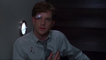 Movie still from “The Way of the Gun” (2000), directed by Christopher McQuarrie – A man with a bandage on his face and a bandage on his eye; Close Up shot, High angle