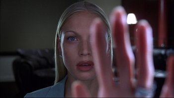 Movie still from “The Way of the Gun” (2000), directed by Christopher McQuarrie – A young blonde haired woman holding her hand up to her face; Close Up shot, Low angle