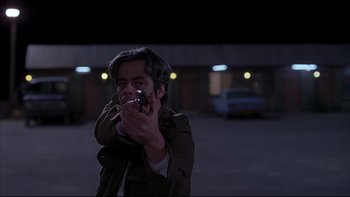 Movie still from “The Way of the Gun” (2000), directed by Christopher McQuarrie – A man is holding a gun in his hand; Medium shot, Low angle