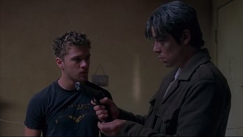 Movie still from “The Way of the Gun” (2000), directed by Christopher McQuarrie – A man holding a gun and another man holding a gun; Medium shot, Over the shoulder angle