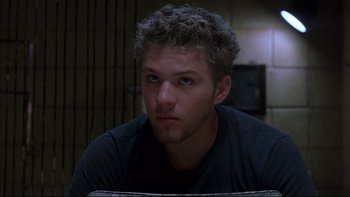 Movie still from “The Way of the Gun” (2000), directed by Christopher McQuarrie – A person sitting in front of a window; Close Up shot, Low angle