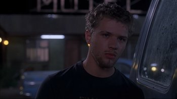 Movie still from “The Way of the Gun” (2000), directed by Christopher McQuarrie – A young man with a beard is looking at the camera; Close Up shot, Low angle