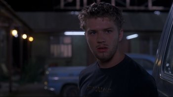 Movie still from “The Way of the Gun” (2000), directed by Christopher McQuarrie – A man with a beard is looking at the camera; Close Up shot, Over the shoulder angle