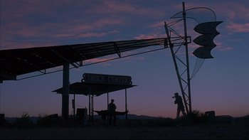 Movie still from “The Way of the Gun” (2000), directed by Christopher McQuarrie – Two men standing next to a truck stop at dusk; Extreme Wide shot, Low angle