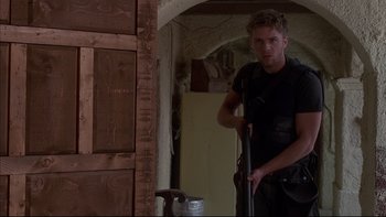 Movie still from “The Way of the Gun” (2000), directed by Christopher McQuarrie – A man holding a hammer in a room; Medium shot, Low angle