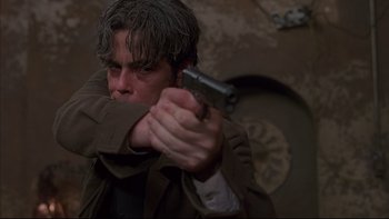 Movie still from “The Way of the Gun” (2000), directed by Christopher McQuarrie – A man holding a gun in his hand; Close Up shot, Low angle