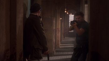 Movie still from “The Way of the Gun” (2000), directed by Christopher McQuarrie – A man taking a picture of another man holding a camera; Medium shot, Over the shoulder angle