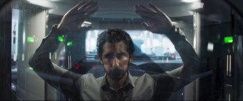 Movie still from “The Wedding Guest” (2018), directed by Michael Winterbottom – A man with his hands up behind a car window; Close Up shot, Low angle