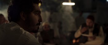 Movie still from “The Wedding Guest” (2018), directed by Michael Winterbottom – A person with a beard; Close Up shot, Over the shoulder angle