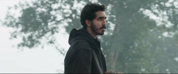 Movie still from “The Wedding Guest” (2018), directed by Michael Winterbottom – A person wearing a jacket; Close Up shot, Over the shoulder angle