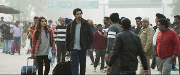 Movie still from “The Wedding Guest” (2018), directed by Michael Winterbottom – A group of people walking on a sidewalk; Medium shot, Low angle
