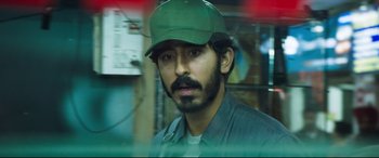 Movie still from “The Wedding Guest” (2018), directed by Michael Winterbottom – A person wearing a hat; Close Up shot, Low angle