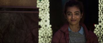 Movie still from “The Wedding Guest” (2018), directed by Michael Winterbottom – A young woman in a red jacket smiling for the camera; Close Up shot, Over the shoulder angle