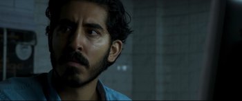 Movie still from “The Wedding Guest” (2018), directed by Michael Winterbottom – A person wearing a blue shirt; Close Up shot, Over the shoulder angle
