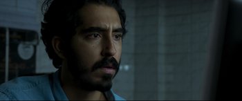 Movie still from “The Wedding Guest” (2018), directed by Michael Winterbottom – A person wearing a blue shirt; Close Up shot, Over the shoulder angle