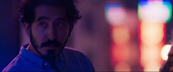 Movie still from “The Wedding Guest” (2018), directed by Michael Winterbottom – A person wearing a shirt; Close Up shot, Over the shoulder angle