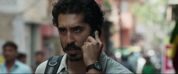 Movie still from “The Wedding Guest” (2018), directed by Michael Winterbottom – A person talking on a cell phone; Close Up shot, Over the shoulder angle