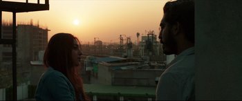 Movie still from “The Wedding Guest” (2018), directed by Michael Winterbottom – A man and a woman are looking at one another; Medium shot, Over the shoulder angle