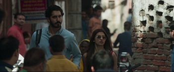 Movie still from “The Wedding Guest” (2018), directed by Michael Winterbottom – A man and a woman walking down a street; Medium shot, Over the shoulder angle
