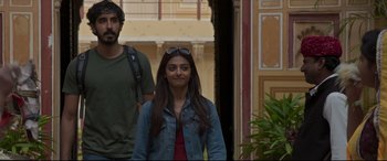 Movie still from “The Wedding Guest” (2018), directed by Michael Winterbottom – A man and a woman walking down a street; Medium shot, Low angle