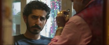 Movie still from “The Wedding Guest” (2018), directed by Michael Winterbottom – A person sitting in front of a mirror; Close Up shot, Over the shoulder angle