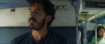 Movie still from “The Wedding Guest” (2018), directed by Michael Winterbottom – A man with a goatee sitting in a car; Close Up shot, Low angle