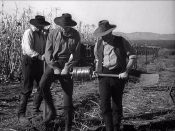 Movie still from “The Westerner” (1940), directed by William Wyler – A group of men standing in a field with a shovel; Wide shot, Low angle