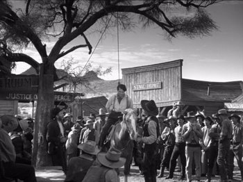 Movie still from “The Westerner” (1940), directed by William Wyler – A crowd of people standing in front of a tree; Wide shot, Low angle