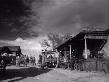 Movie still from “The Westerner” (1940), directed by William Wyler – A black and white photo of people on a dirt road; Extreme Wide shot, Low angle