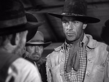 Movie still from “The Westerner” (1940), directed by William Wyler – A black and white photo of a man in a cowboy hat; Medium shot, Over the shoulder angle