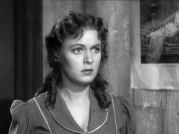 Movie still from “The Westerner” (1940), directed by William Wyler – A black and white photo of a woman in a dress; Close Up shot, Over the shoulder angle