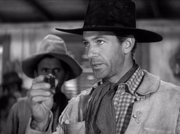 Movie still from “The Westerner” (1940), directed by William Wyler – A man in a cowboy hat holding a cell phone in front of another man in a cowboy hat; Close Up shot, Low angle