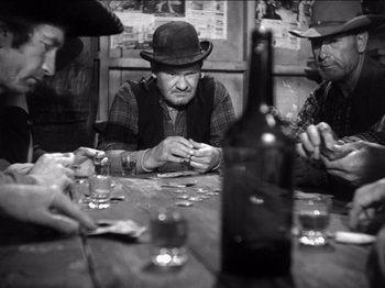 Movie still from “The Westerner” (1940), directed by William Wyler – A group of men sitting at a table playing cards; Medium shot, High angle