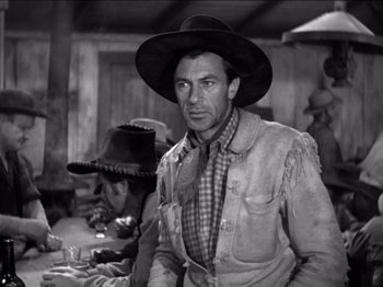 Movie still from “The Westerner” (1940), directed by William Wyler – A man wearing a cowboy hat standing in front of other men; Medium shot, Low angle