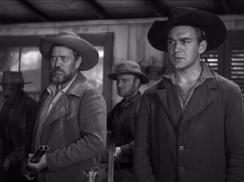 Movie still from “The Westerner” (1940), directed by William Wyler – A black - and - white photo of two men in cowboy hats; Medium shot, Low angle