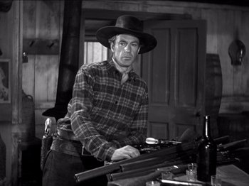 Movie still from “The Westerner” (1940), directed by William Wyler – A man in plaid shirt and hat holding a gun; Medium shot, Low angle