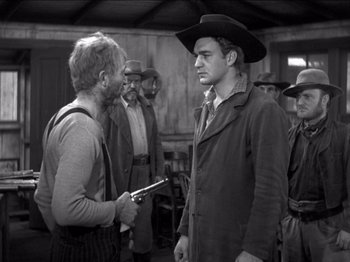 Movie still from “The Westerner” (1940), directed by William Wyler – Two men are talking to each other while others watch; Medium shot, Over the shoulder angle