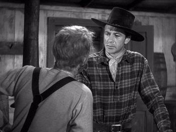 Movie still from “The Westerner” (1940), directed by William Wyler – A man wearing a cowboy hat talking to another man; Medium shot, Over the shoulder angle