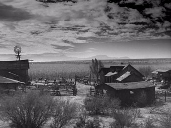 Movie still from “The Westerner” (1940), directed by William Wyler – A black and white photo of a farm in the middle of nowhere; Extreme Wide shot, High angle