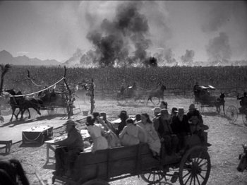 Movie still from “The Westerner” (1940), directed by William Wyler – A group of people riding in a horse drawn carriage; Extreme Wide shot, High angle