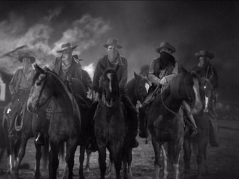 Movie still from “The Westerner” (1940), directed by William Wyler – A black and white photo of a group of men on horses; Wide shot, Low angle